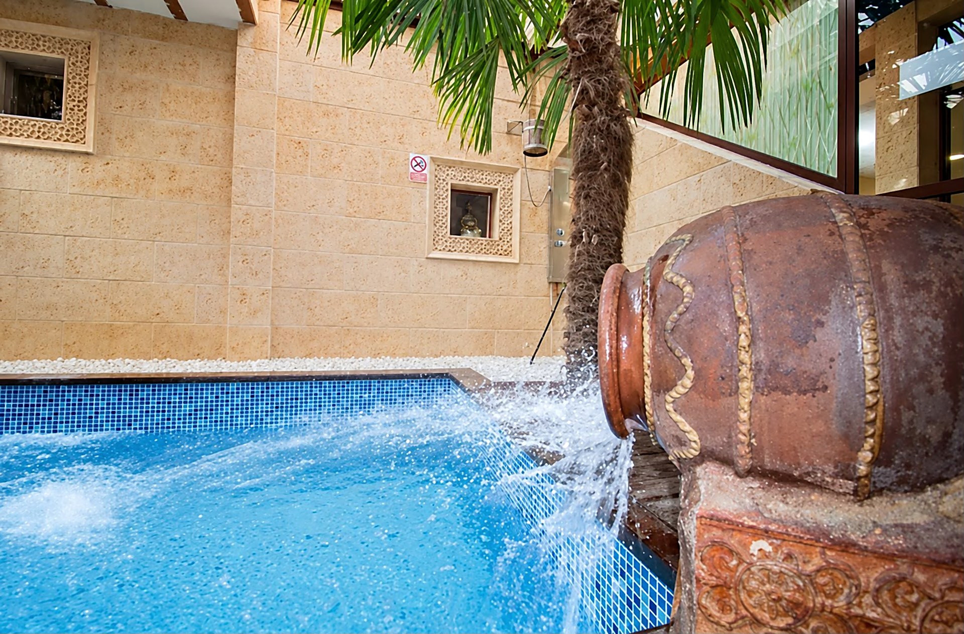 Chorro de agua del cántaro sobre la piscina